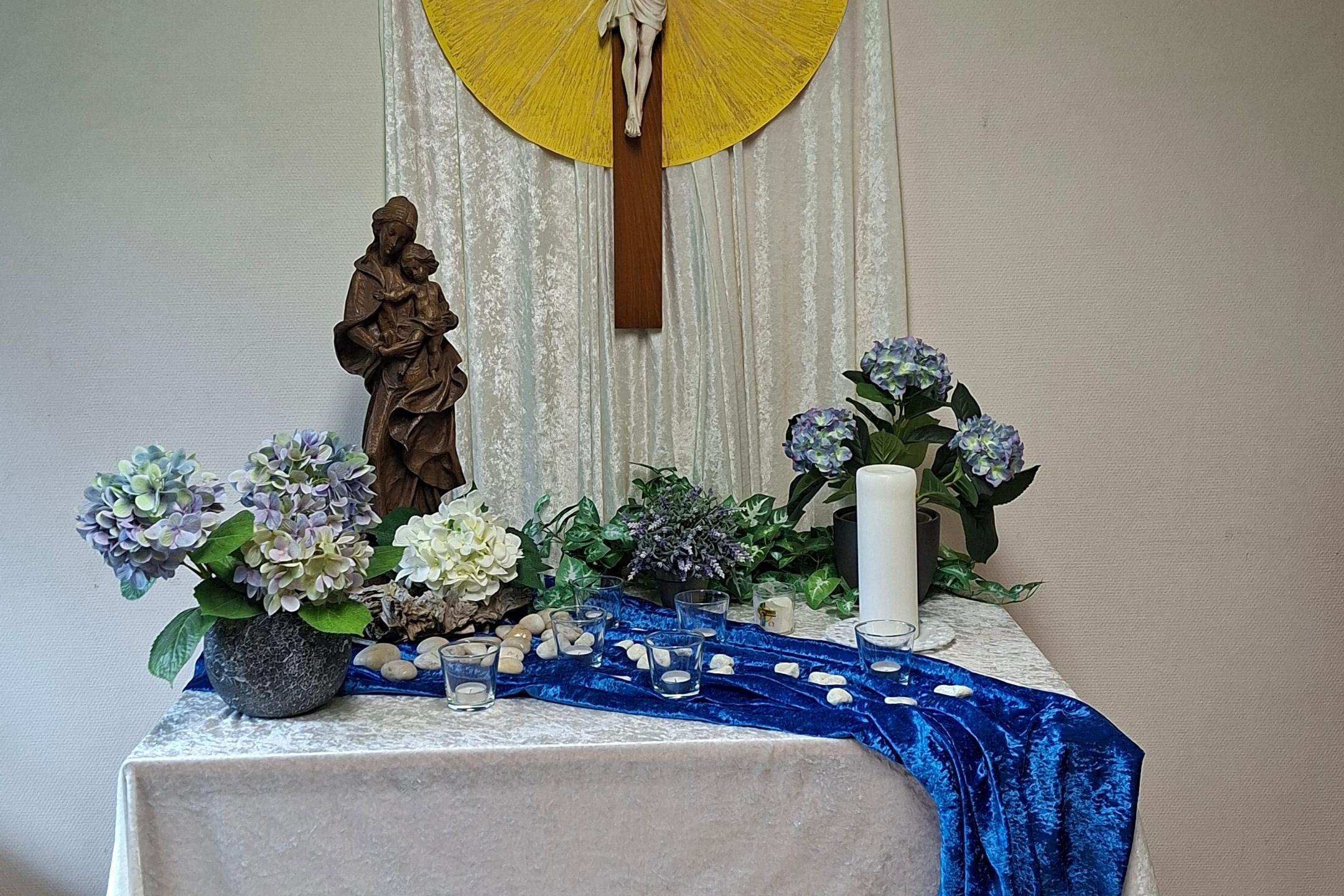 Altar mit Blumenschmuck im Pfarrsälchen Maria-Himmelfahrt Elm/Sprengen