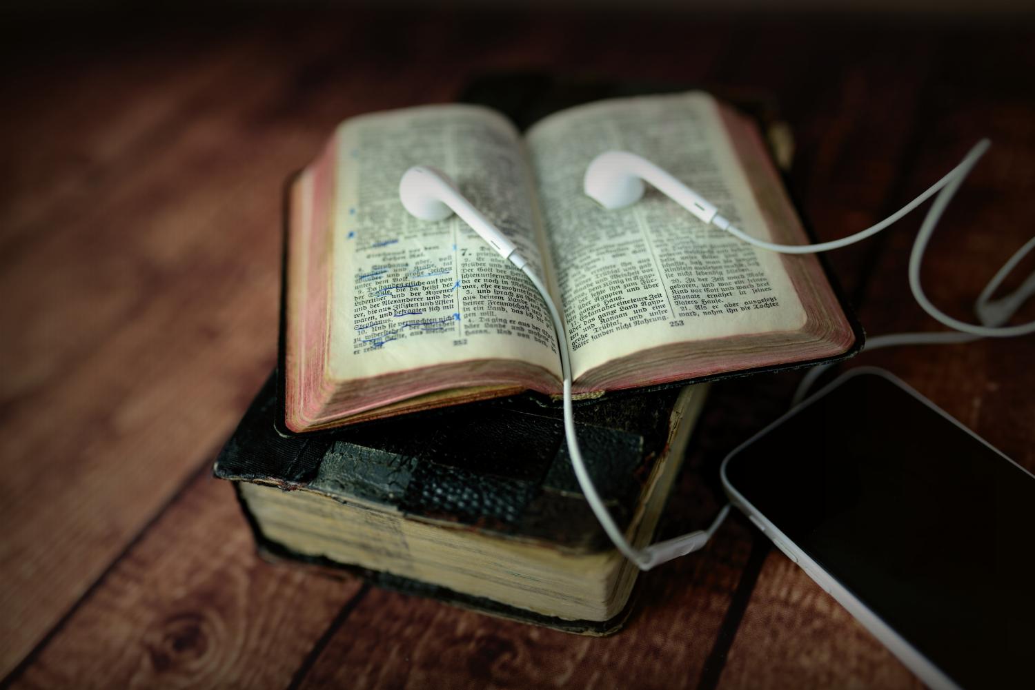 Bibel mit Smartphone und Headset