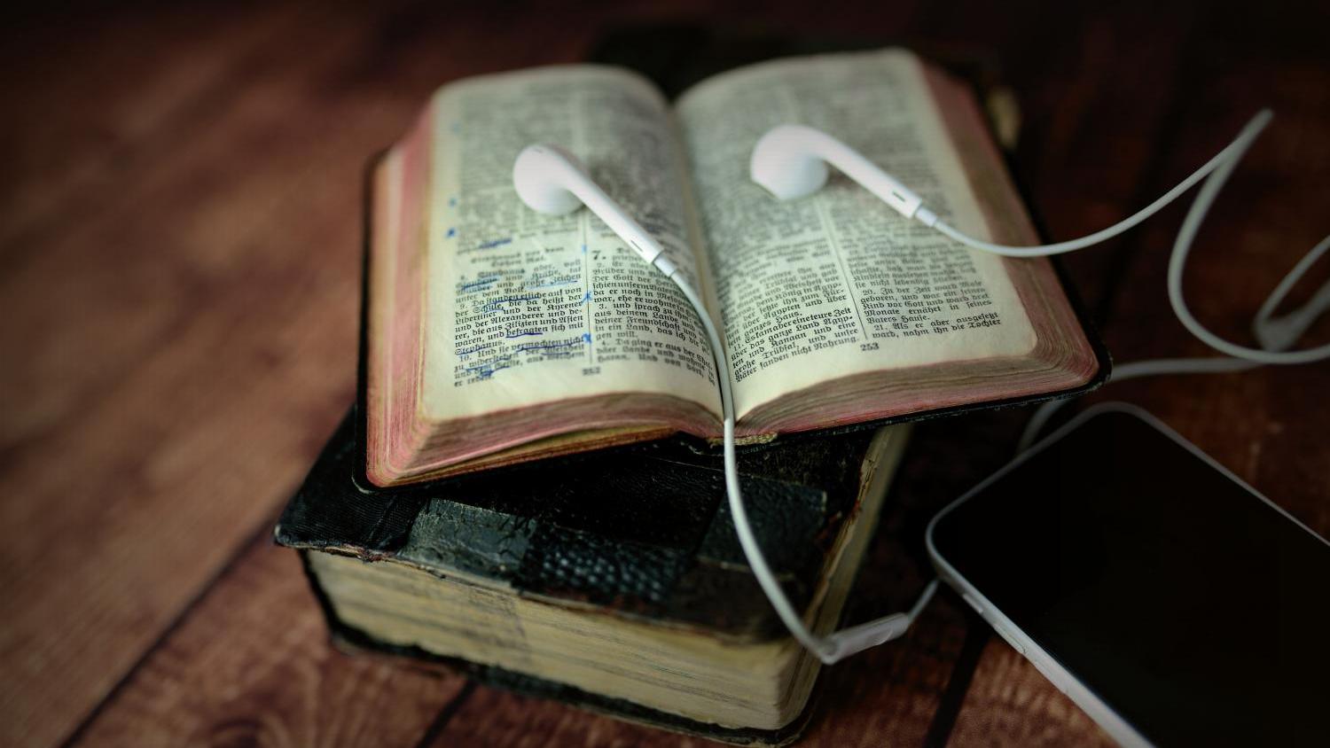 Bibel mit Smartphone und Headset