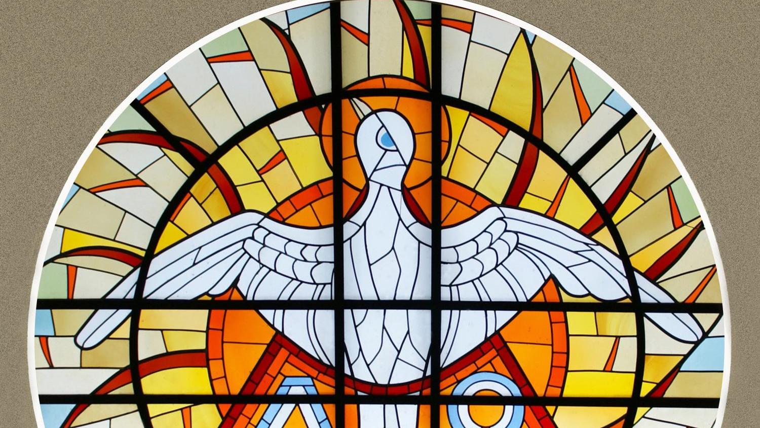 Foto eines runden Dreifaltigkeitsfenster mit Symbolen für die Dreieinigkeit Gottes