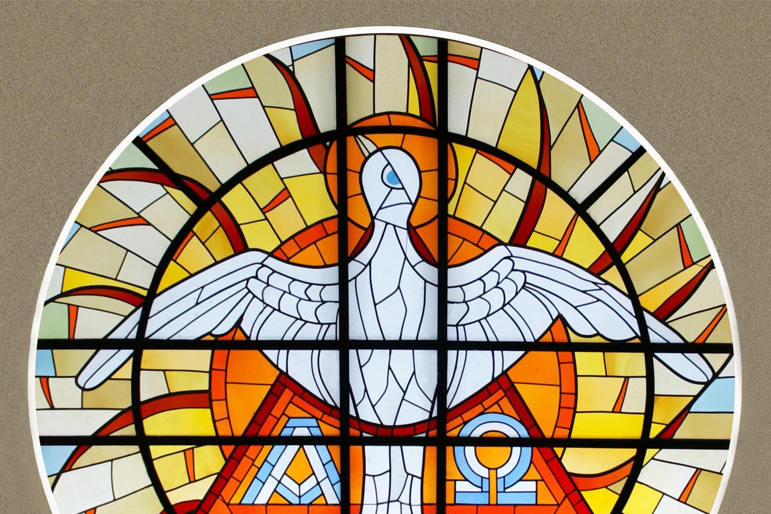 Foto eines runden Dreifaltigkeitsfenster mit Symbolen für die Dreieinigkeit Gottes