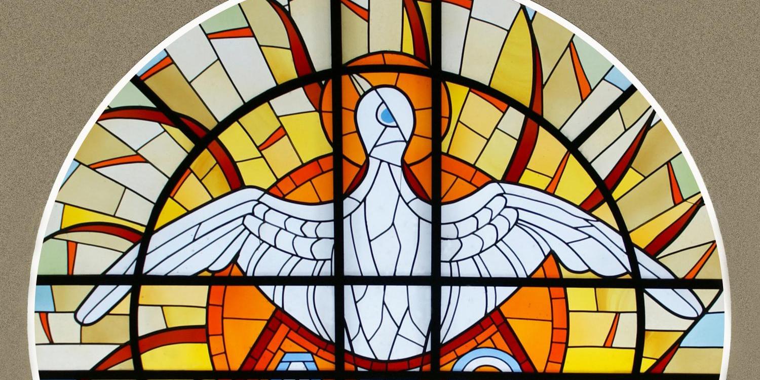 Foto eines runden Dreifaltigkeitsfenster mit Symbolen für die Dreieinigkeit Gottes