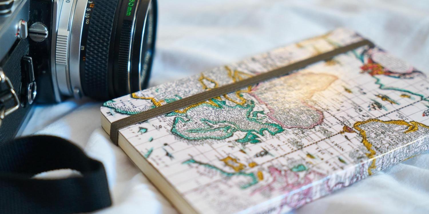 Kamera und Reise-Tagebuch als Symbol für Reisen, Urlaub, Ferien