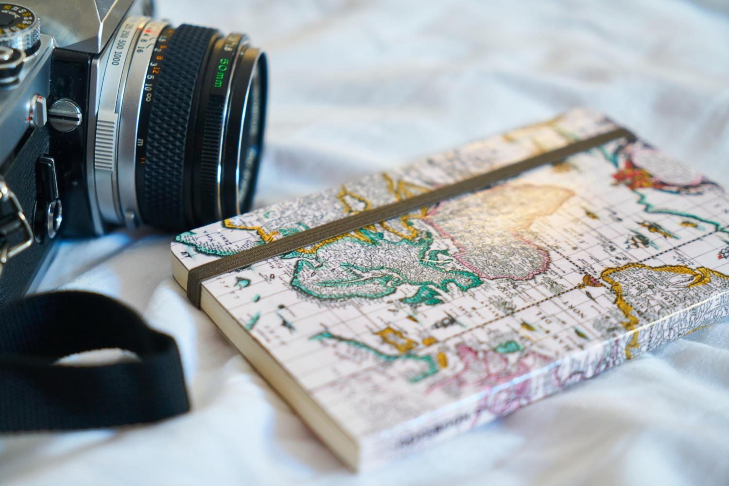 Kamera und Reise-Tagebuch als Symbol für Reisen, Urlaub, Ferien