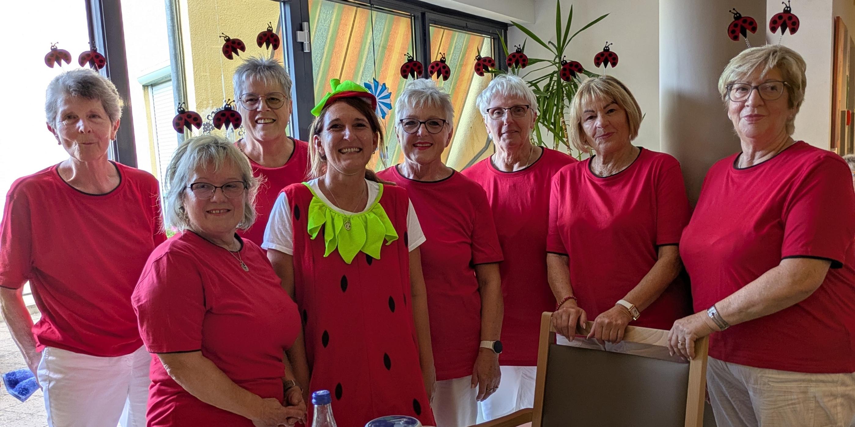 Foto von Mitgliedern des EV St. Martin beim Erdbeerfest 2026; alle haben rote T-Shirts und weiße Hosen an; sechs von sieben haben Marienkäfer Aufsätze im Haar; eine trägt ein Erdbeerkostüm (c) Doris Kopp Foto von Mitgliedern des EV St. Martin beim Erdbeerfest 2026; alle haben rote T-Shirts und weiße Hosen an; sechs von sieben haben Marienkäfer Aufsätze im Haar; eine trägt ein Erdbeerkostüm