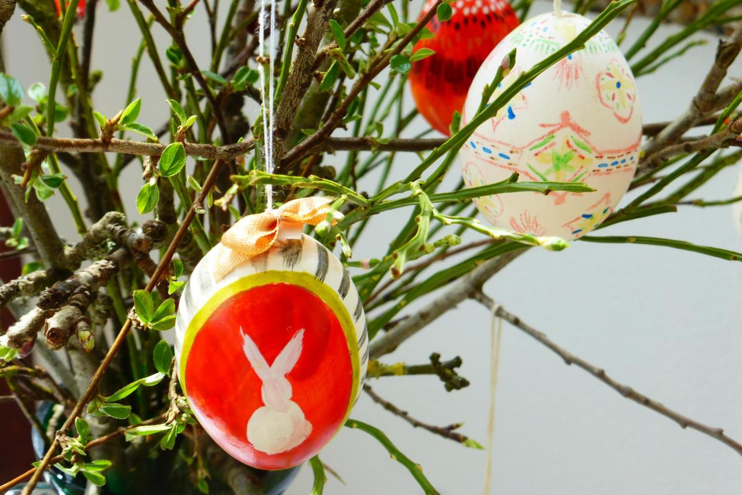 Ein Osterstrauch, an dem drei bemalte Ostereier hängen