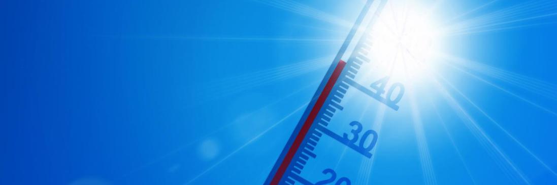 Thermometer vor brütend, heißer Sonne und blauem Himmel