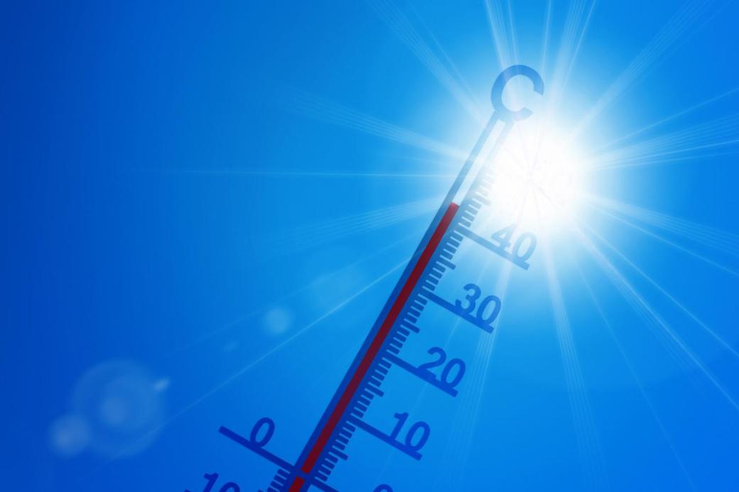 Thermometer vor brütend, heißer Sonne und blauem Himmel