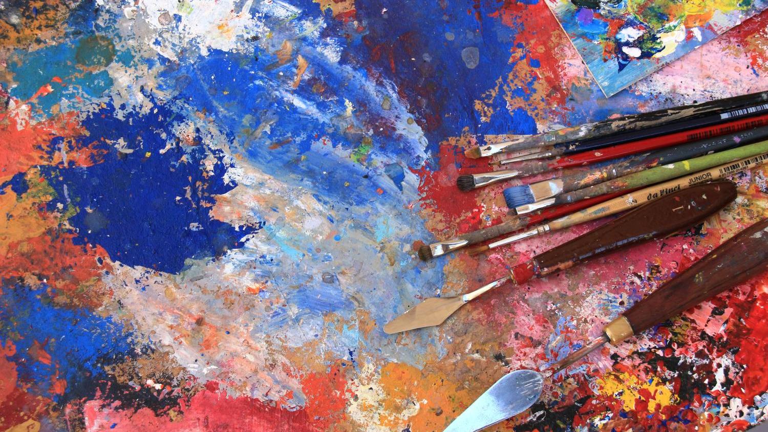 Staffelei mit bunten Farben, Pinseln und Spateln