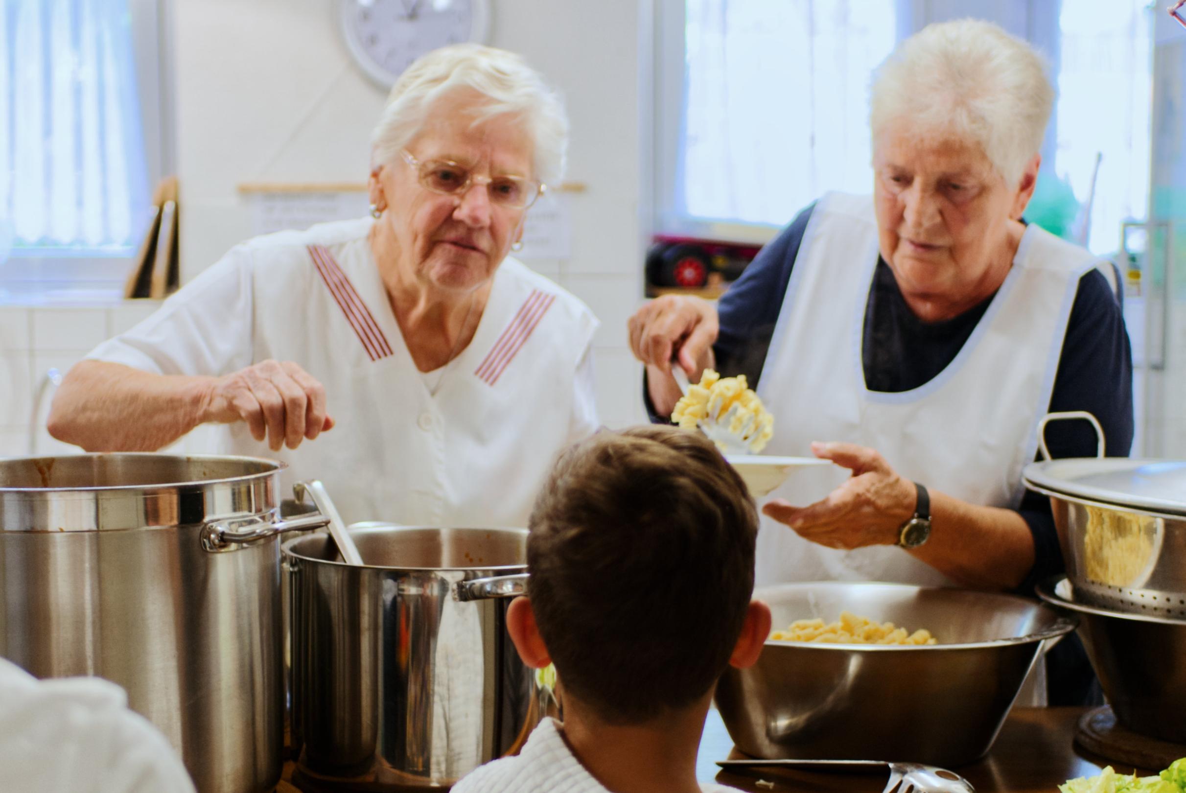 Omas Küche teilt Essen aus