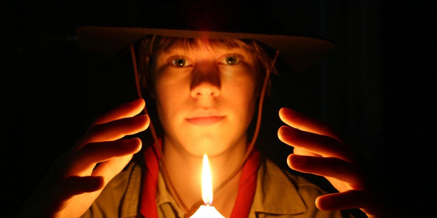Porträt eines Pfadfinders in seiner Uniform, vor dunklem Hintergrund mit einer brennenden Kerze (c) Bild: Christiane Raabe In: Pfarrbriefservice.de Porträt eines Pfadfinders in seiner Uniform, vor dunklem Hintergrund mit einer brennenden Kerze