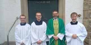 Foto von drei Seminaristen und Pastor Müller vor Seitentür von St. Josef
