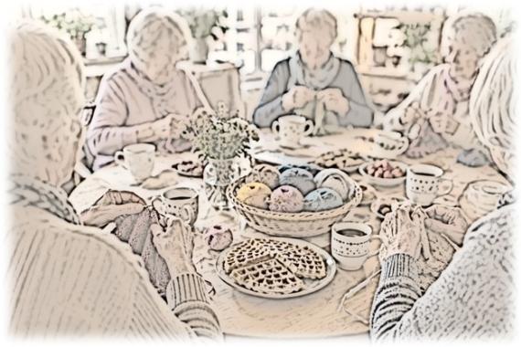 Strickende Seniorinnen sitzen an einem Tisch, auf dem Wollknäuel in einem Korb aber auch Kaffeetassen und Teller mit süßen Waffeln stehen