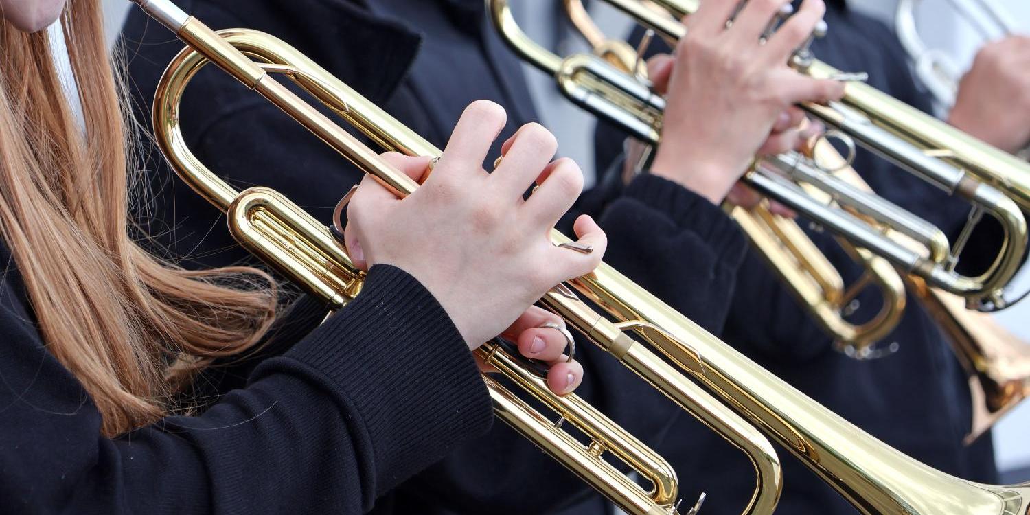 zu sehen sind zwei Trompetenspieler mit Ihren Instrumenten als Teil eines Orchesters