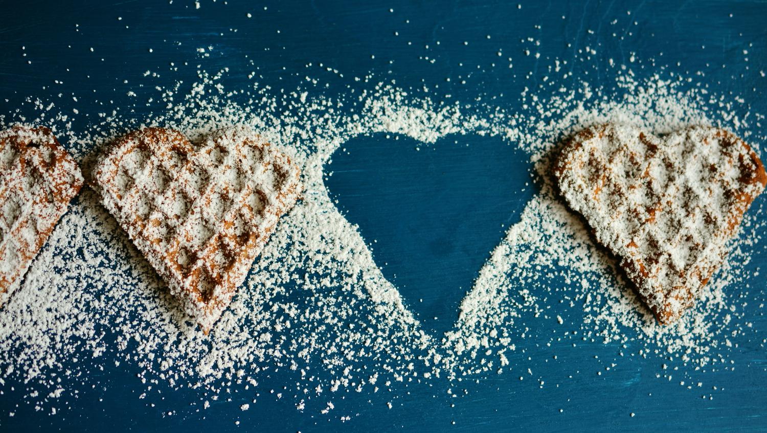 Waffeln in Herzform mit Puderzucker bestreut vor blauem Hintergrund; eine Waffel (2. von rechts) fehlt (c) Bild: congerdesign / Pixabay.com - Lizenz In: Pfarrbriefservice.de Waffeln in Herzform mit Puderzucker bestreut vor blauem Hintergrund; eine Waffel (2. von rechts) fehlt