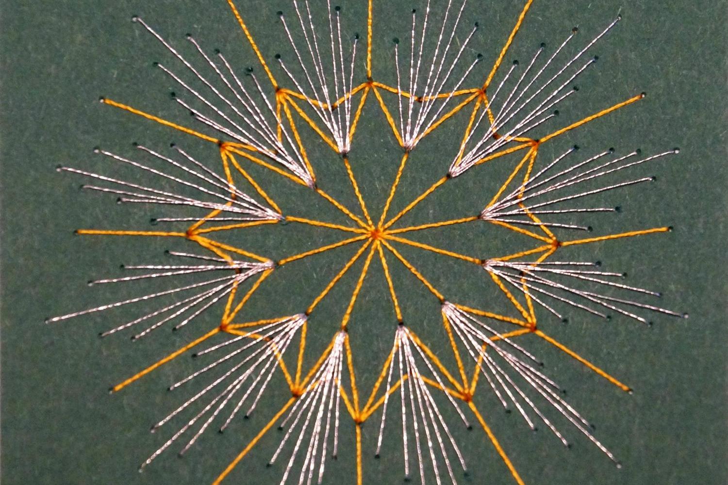 ein mit Fäden (weiß und gelb) vor grünem Hintergrund gespannter, feingliedriger Weihnachtsstern